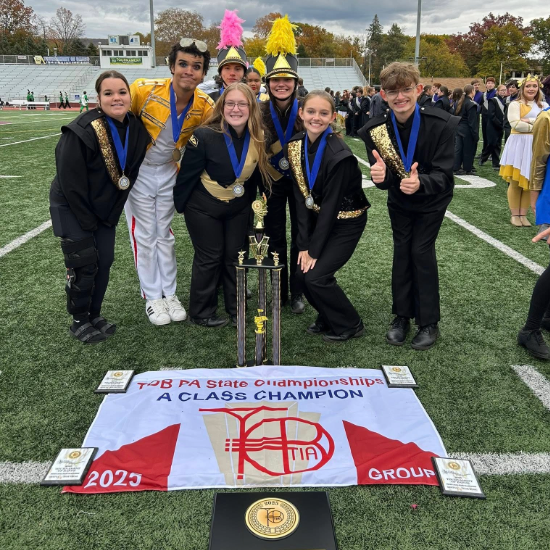  Group of band members around awards won at state finals